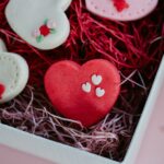 From above of tasty heart shaped ginger cookies with decoration on sugar glaze in gift box during festive occasion